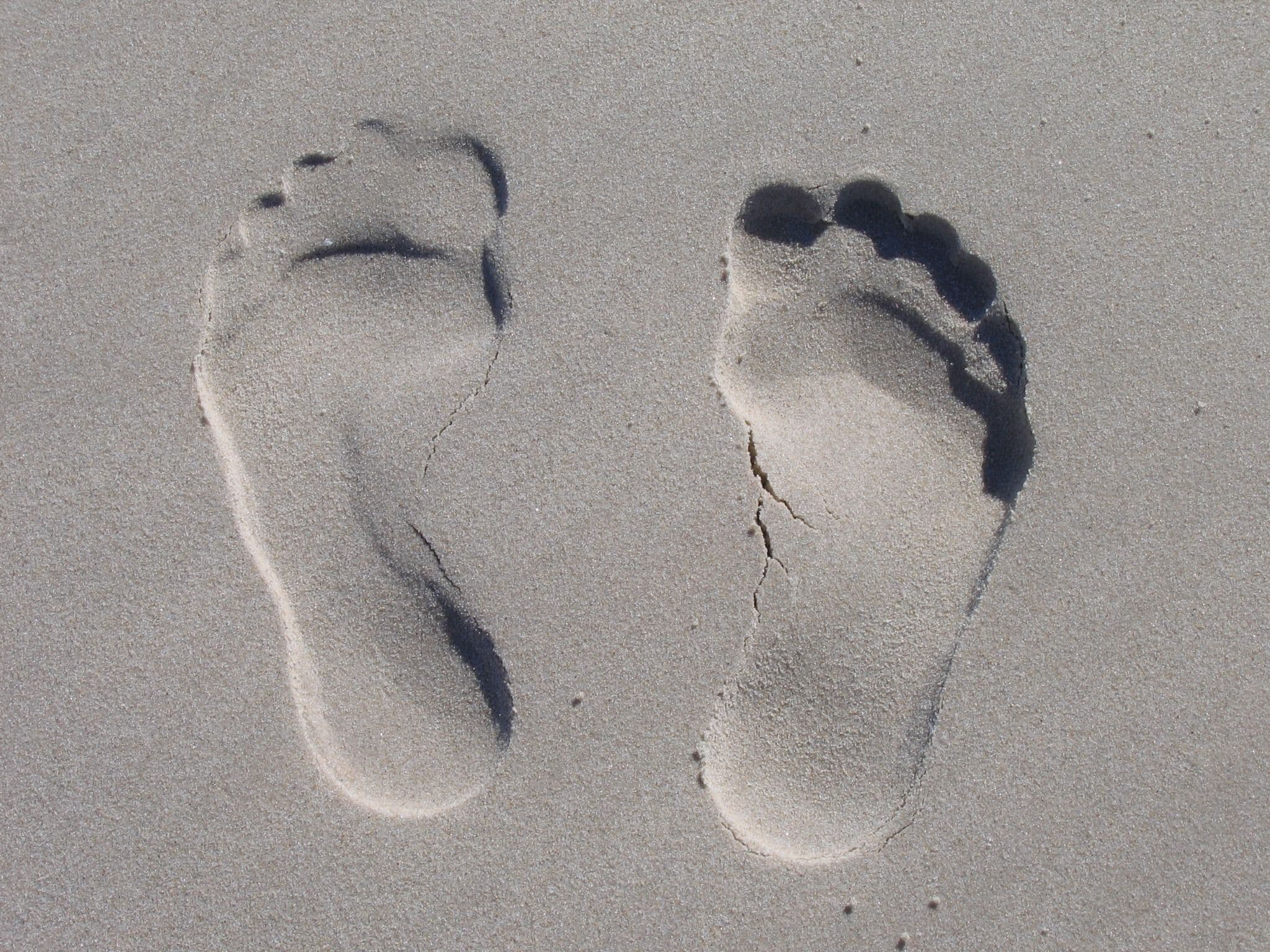 A pair of bare footprints left in the sand